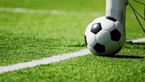 Fußball neben Torpfosten Ein Fußball liegt auf dem Fußballfeld neben dem Torpfosten.