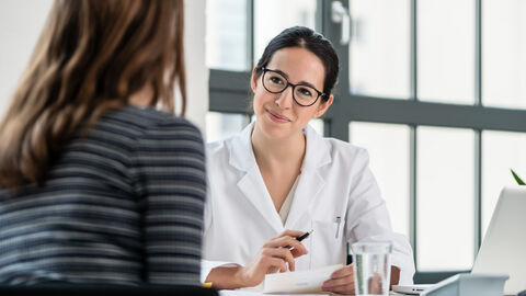 Beratungsgespräch Eine Ärztin an einem Schreibtisch mit einer Patientin im Beratungsgespräch.