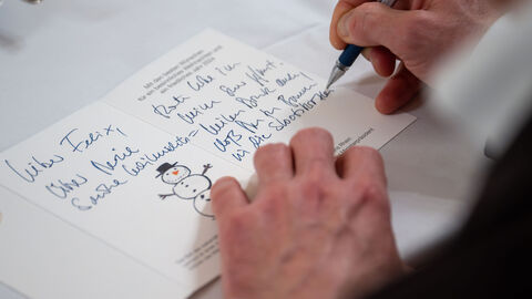 Nahaufnahme: eine Karte mit Schneemann wird beschriftet