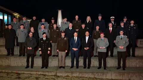 Mehrere Männer in verschiedenen militärischen Uniformen stehen zum Gruppenfoto aufgestellt auf Treppen verteilt.