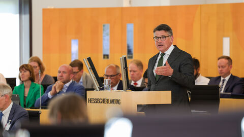 Boris Rhein spricht im Hessischen Landtag Mann hält Rede am Rednerpult. Auf dem Pult steht "Hessischer Landtag!