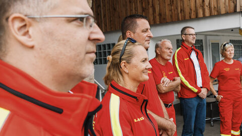 MP vor Ort Nordhessen Mehrere Personen in rot-gelber Kleidung stehen vor einem Gebäude.
