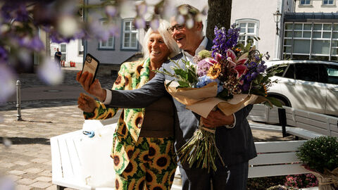 Ministerpräsident Boris Rhein in Bad Arolsen Ein Mann steht neben einer Frau mit einem Blumenstrauß und macht ein Selfie,