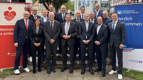 Gruppenbild: Vertreterinnen und Vertretern der Banken stehen mit Finanzminister Lorz gemeinsam auf einem Platz.