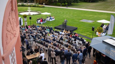 Blick auf ein Publikum im Freien, vor dem Staatsminister Jung eine Ansprache hält.