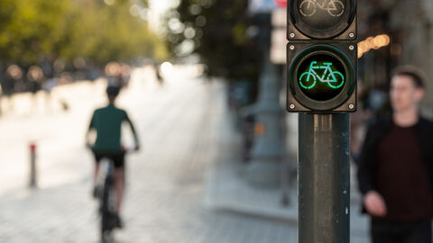 Person auf dem Fahrrad und zu Fuß an einer Farhrradampel 