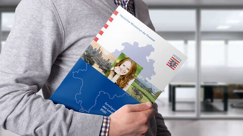 Ein Mann trägt den Beteiligungsbericht 2020 des Landes Hessen. Ein Mann trägt den Beteiligungsbericht 2020 des Landes Hessen.