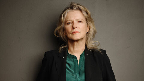 Eine Frau steht vor einer grauen Wand