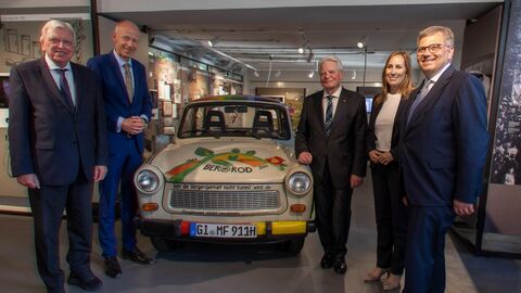 Lern- und Erinnerungsort Notaufnahmelager Gießen eröffnet Fünf Menschen stehen in Businesskleidung um ein Auto herum.