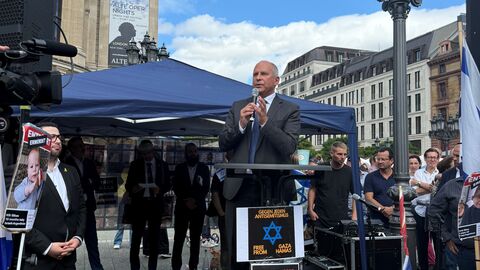 Innenminister Roman Poseck bei seiner Ansprache auf der Versammlung „United we stand – Gegen jede Art von Antisemitismus“ Roman Poseck steht auf einem Rednerpult und spricht in ein Mikrofon